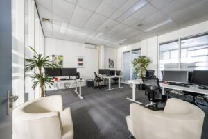 Modern kantoor aan de Van der Madeweg met meerdere werkplekken, bureaustoelen, beeldschermen en planten.
